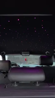 Stele violet pe plafonul VW, văzute din portbagaj.