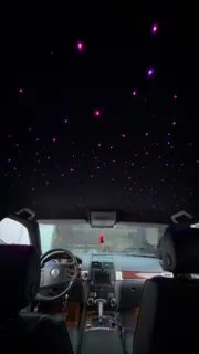 Plafon negru cu stele violet, văzut spre bordul Volkswagen.